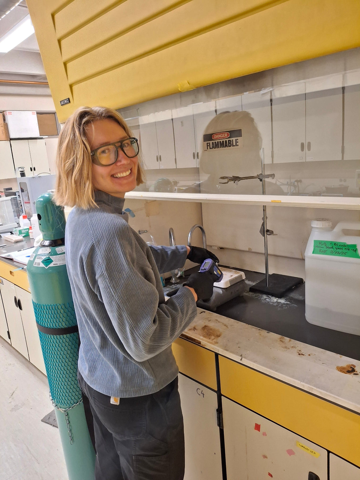 Person using a machine in a lab setting with yellow lockers in the background