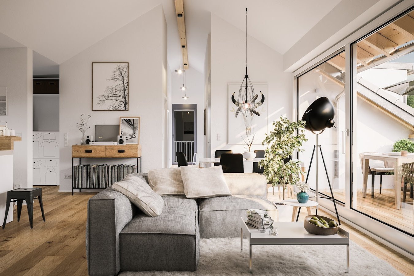 big grey couch in living room looking out at big windows and deck